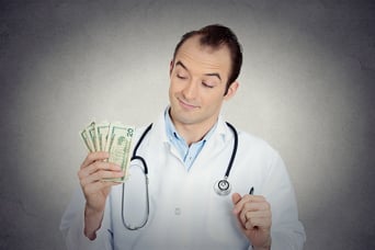 Closeup portrait grumpy greedy miserly health care professional, male doctor holding, protecting his money dollars in hand isolated grey wall background. Negative human emotions, facial expressions.jpeg